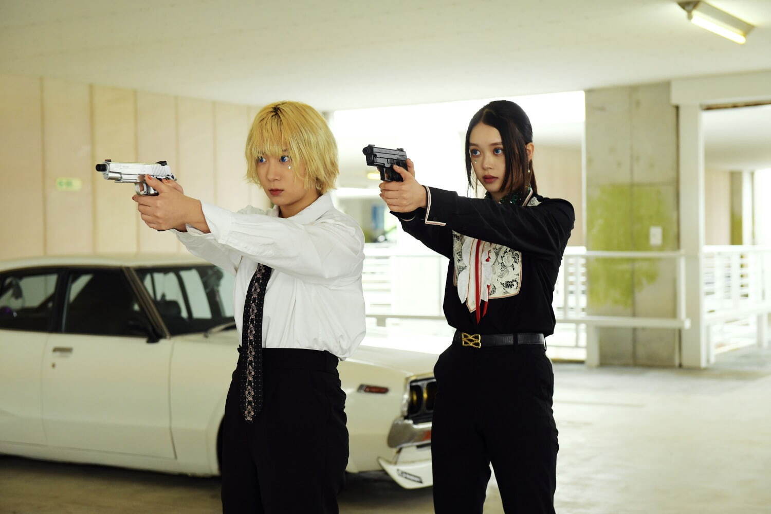 Mahiro and Chisato pointing handguns offscreen in Baby Assassins