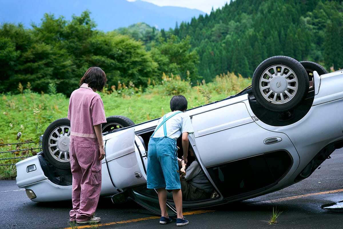 Noriko and Haru examine a flipped car in Yusuke Morii's Route 29