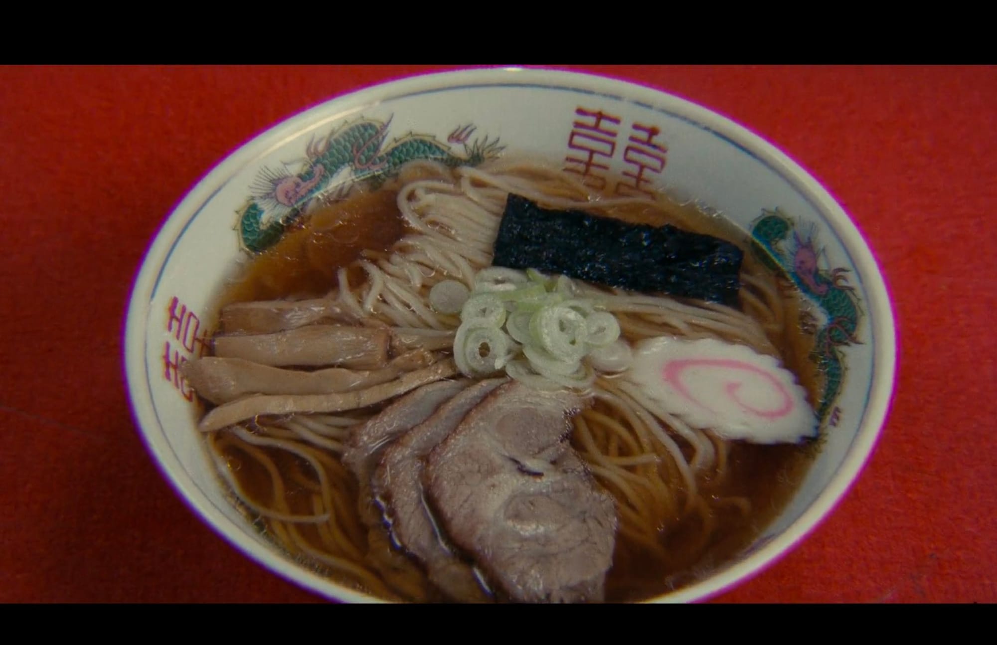 Tampopo bowl or ramen on a red table.