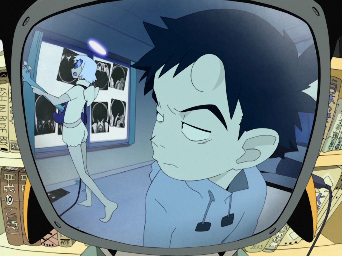 Naota (with a horn on his head) looks skeptically at a woman named Haruka, who is wearing an angel costume. She is standing in front of a projection screen displaying images of Naota's brain.