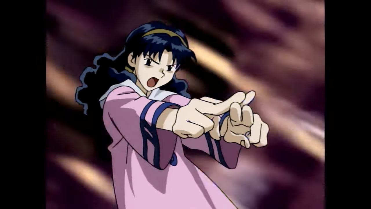 Mia, a girl with black hair who is wearing a pink dress, crosses her fingers to activate a powerful magic spell.