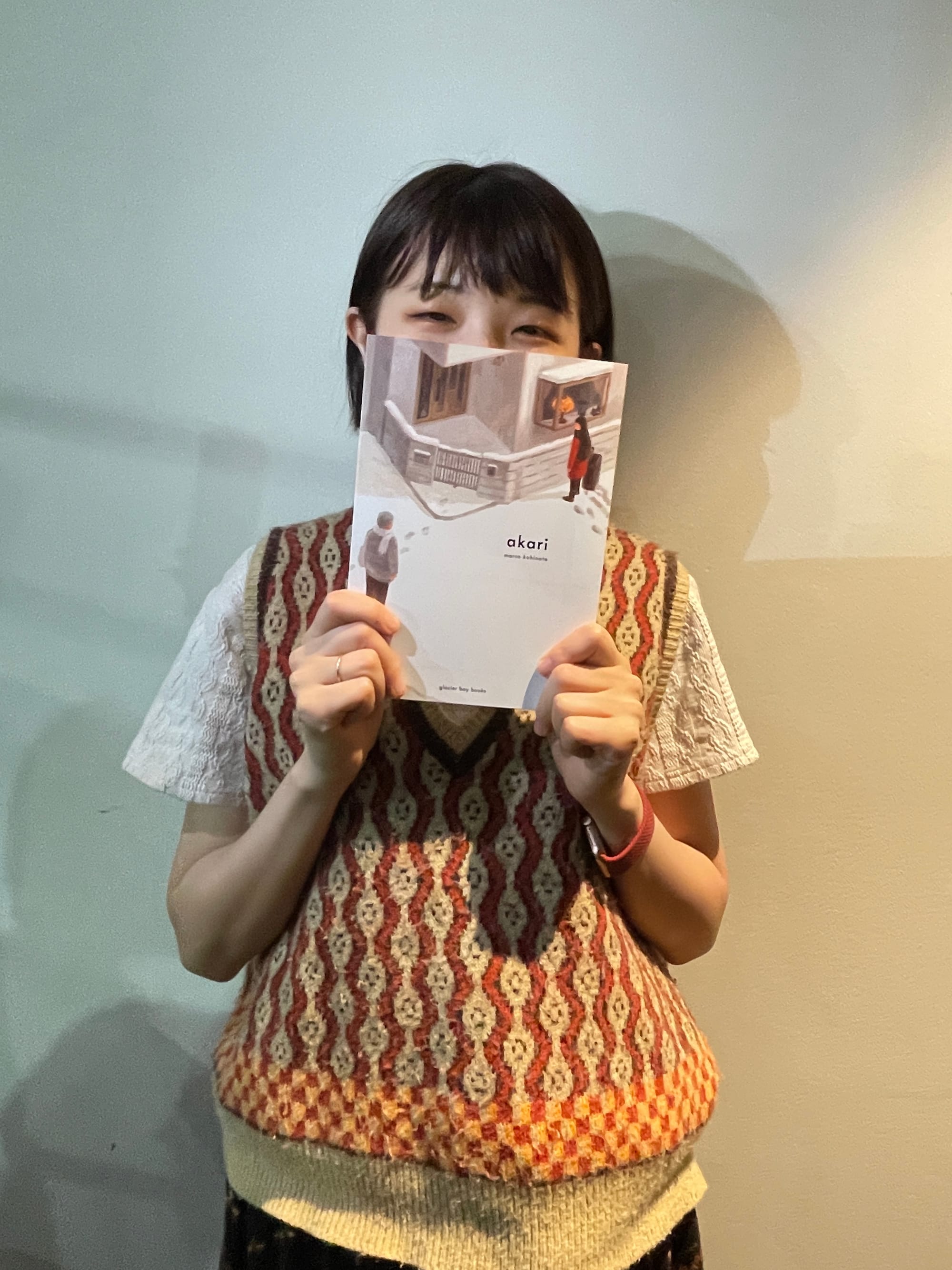 Marco Kohinata holding a copy of the Akari manga. 