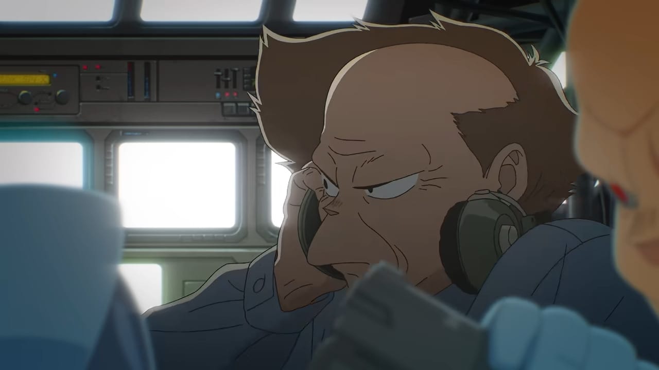 Chief Aramaki, a balding older man with wrinkles, listens to a message over his headphones.