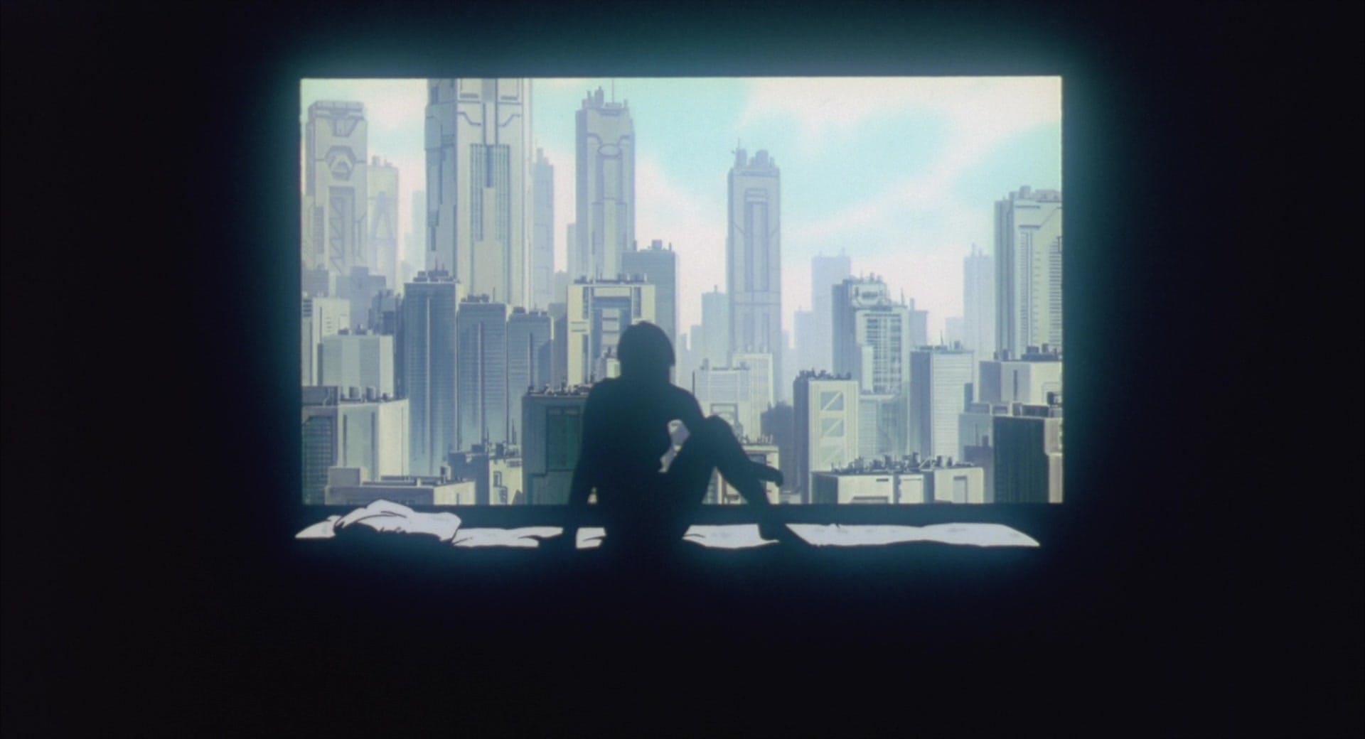 A silhouette of Motoko looking out at the city, from Ghost in the Shell (1995.)